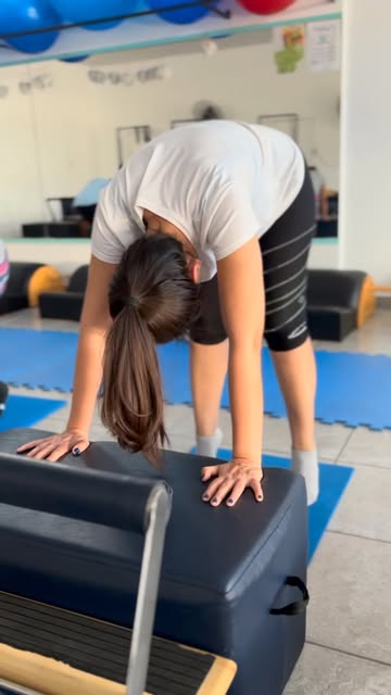 Clienta apoyada en la caja del reformer, en la sala de Centro GC